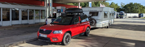 Ein Wohnwagengespann an einer Tankstelle.