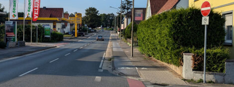 Geh- und Radweg an einer leicht ansteigenden Straße.