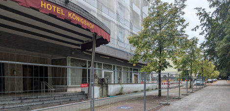 Ein Bauzaun sperrt den Zugang zum ehemals prunkvollen Eingang des Hotels Königshof an der Straße "Am Kurpark"