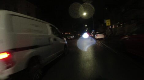 Ein weißer Van überholt recht knapp und zügig einen Fahrradfahrer. Das Bild ist von einer auf dem Lenker montierten Dashcam aufgenommen.